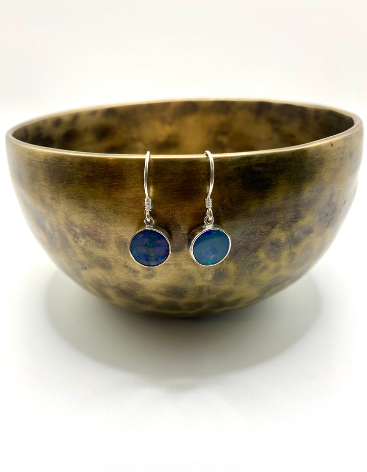 Blue opal drop earrings photographed beside a brass singing bowl showing full drop length and earring scale
